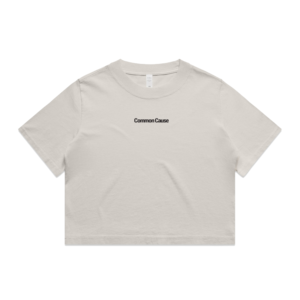 A light beige short-sleeve crop top t-shirt with 'Common Cause' printed in black text on the chest, displayed flat against a solid white background.