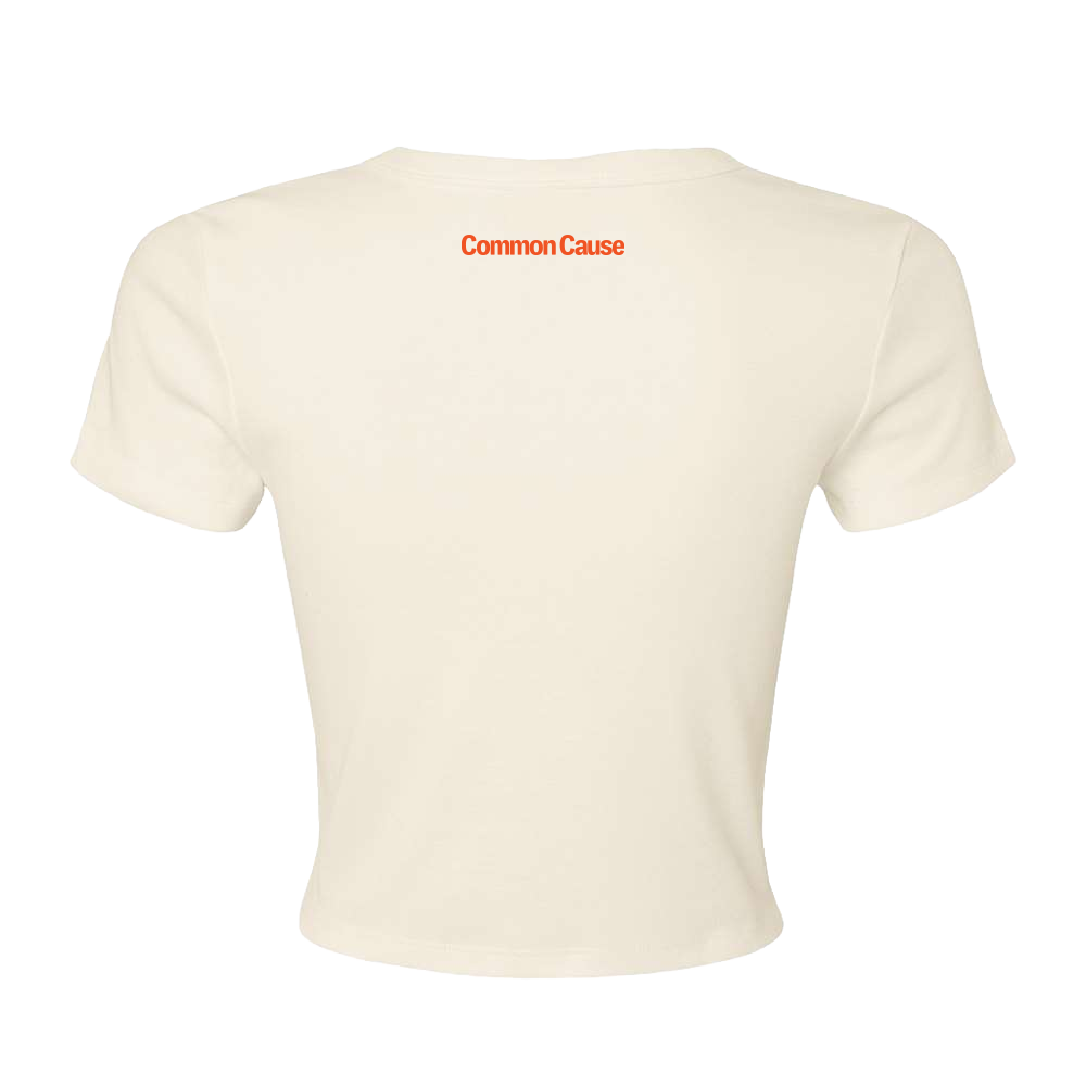 An off-white cropped short-sleeve t-shirt shown from the back, featuring the words 'Common Cause' printed in orange across the upper back.