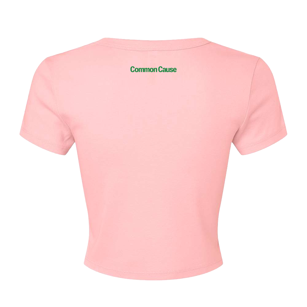 A light pink short-sleeve crop top shown from the back, featuring the words 'Common Cause' printed in green across the upper back, set against a plain white background.