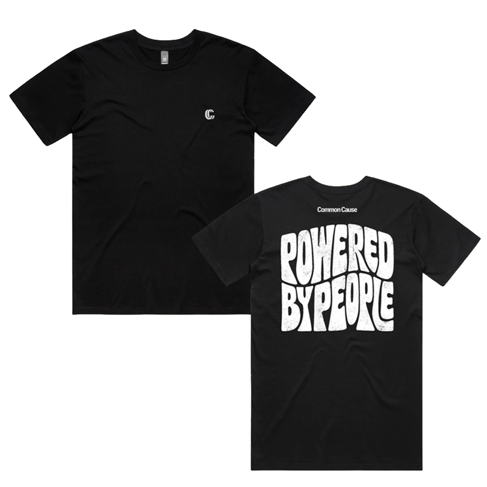 Two black short-sleeve t-shirts shown on a white background, one displaying the front with a small white circular logo on the left chest, and the other showing the back with a large white retro-style graphic reading 'POWERED BY PEOPLE' and 'CommonCraze' printed above it.